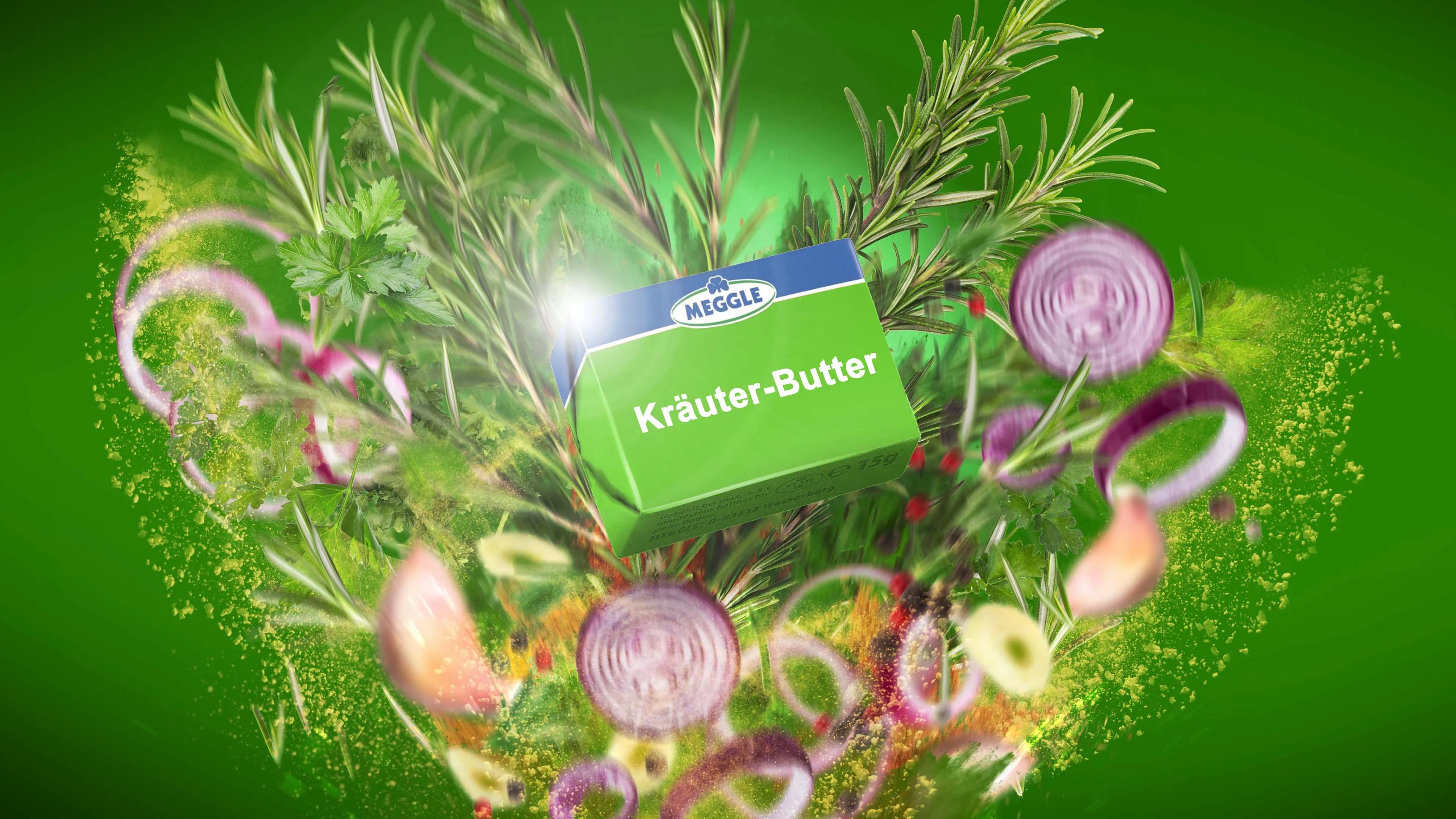 Meggle herb butter pack bursting from an explosion of rosemary, parsley, red onion rings and spice, on a green backdrop