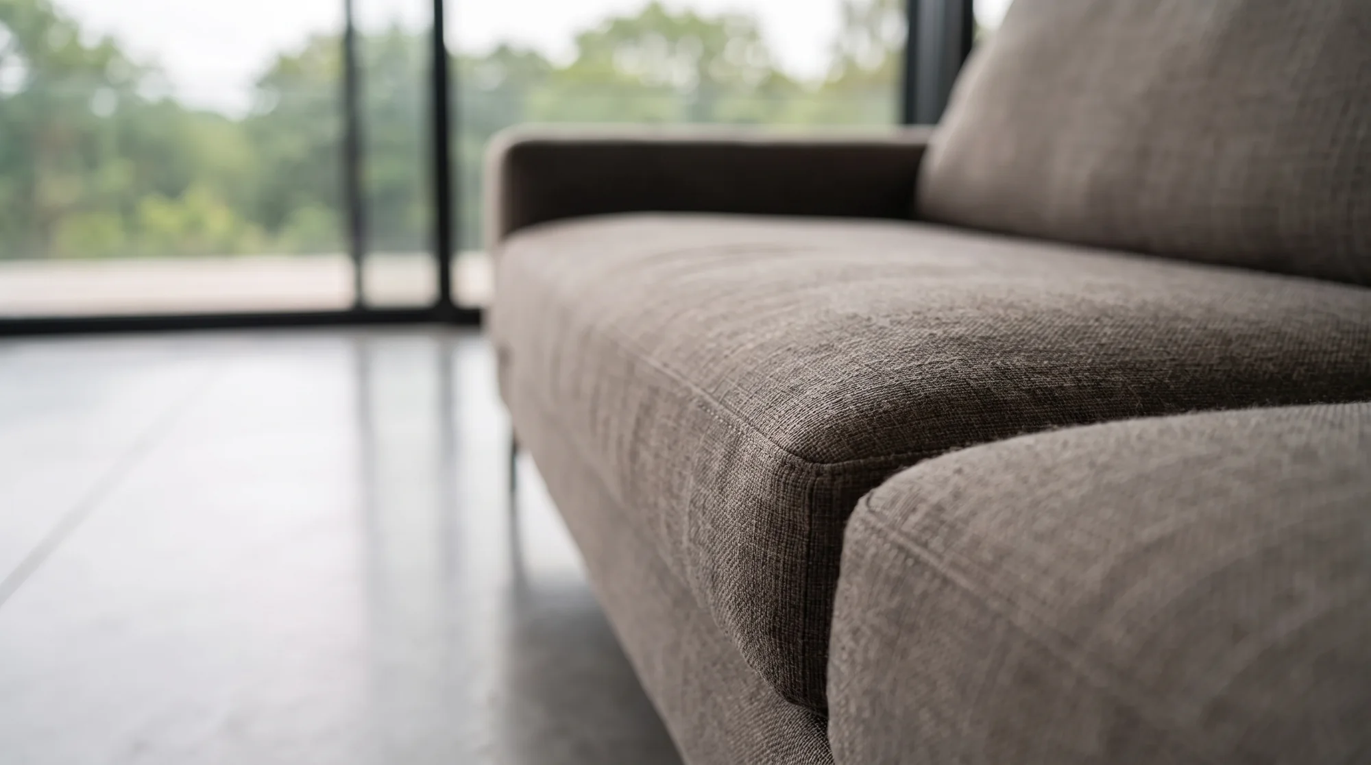 Close-up of the sofa upholstery, glazing and trees soft in the background