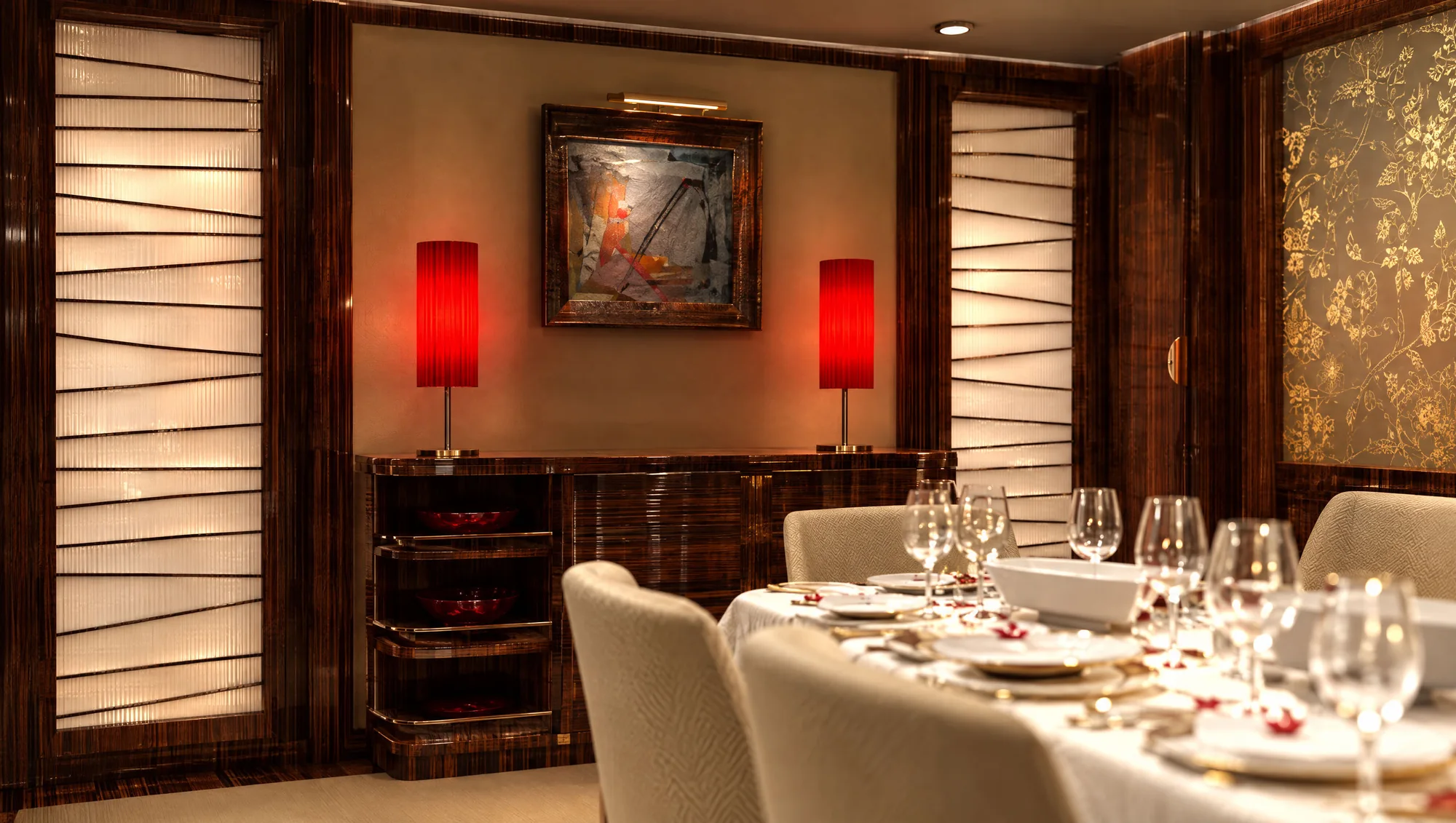 Sideboard in high-gloss wood with red column lamps, red glass bowls and a framed painting