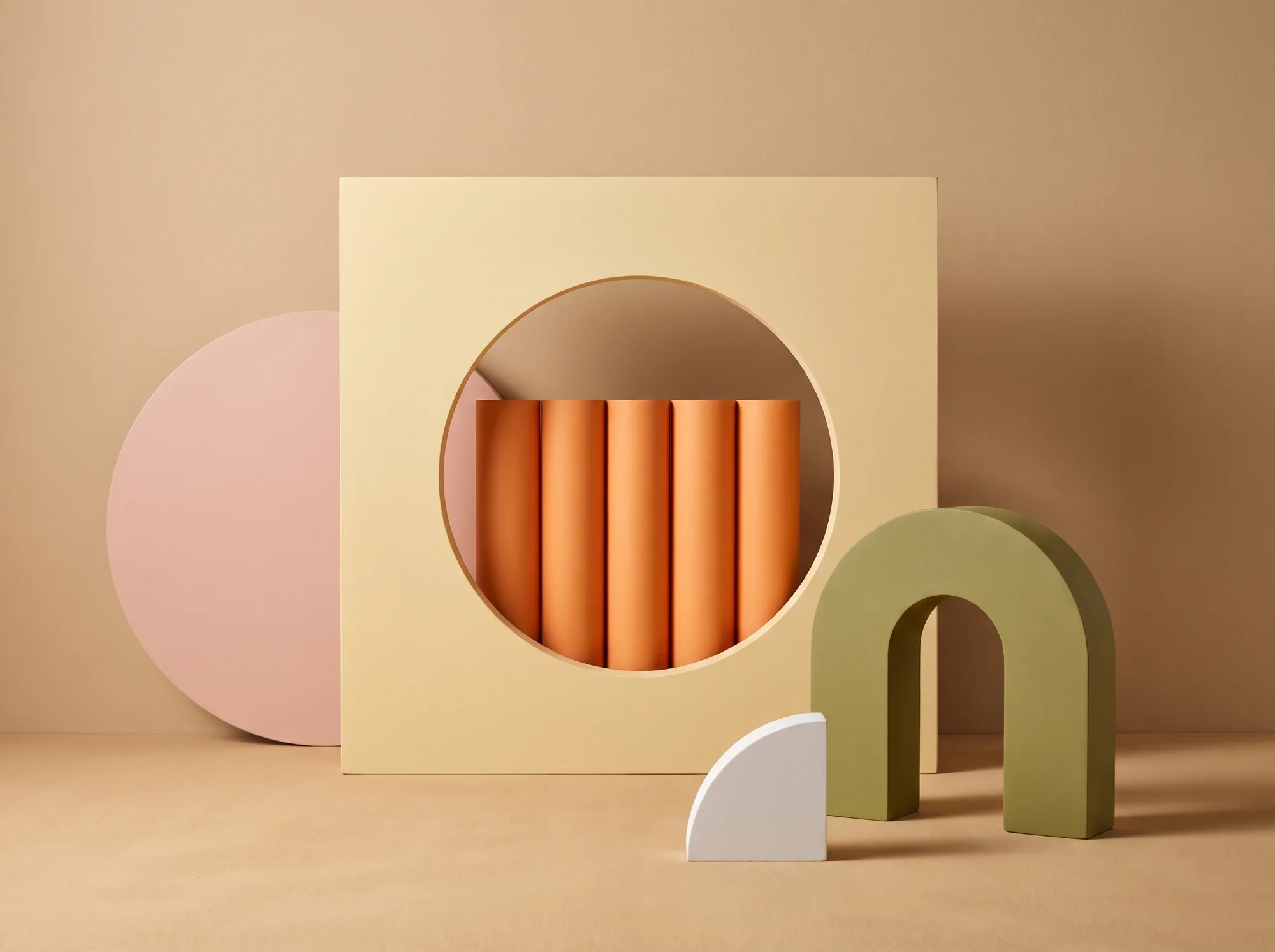 Beige set — pink disc, cream square with a round cutout filled with orange tubes, sage arch and a white quarter-disc